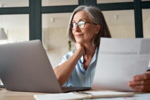 Senior woman writing her Resume on her laptop