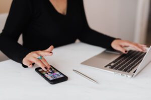 Employer using social media to search - woman on phone and laptop