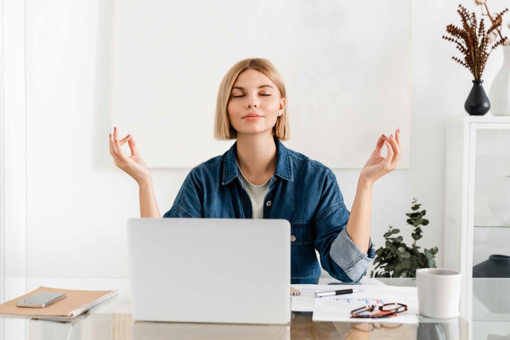 Relaxed office professional meditating at work after working a temporary job. Work life balance concept. 