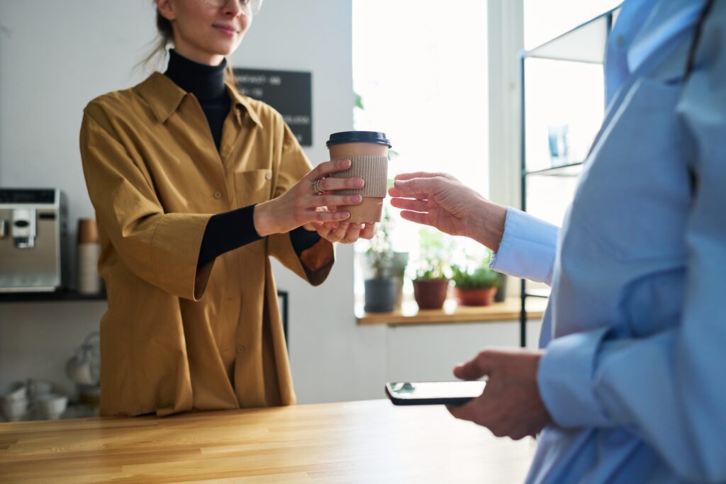 Woman receiving coffee to boost energy, following healthy lifestyle tips for office professionals.